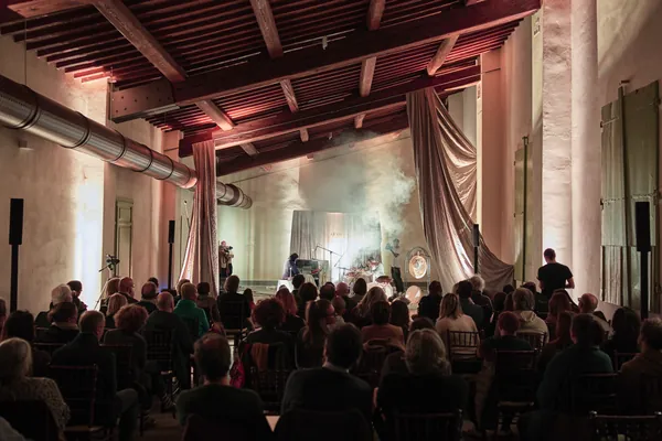 Pubblico nella sala di una villa storica con soffitto a travi